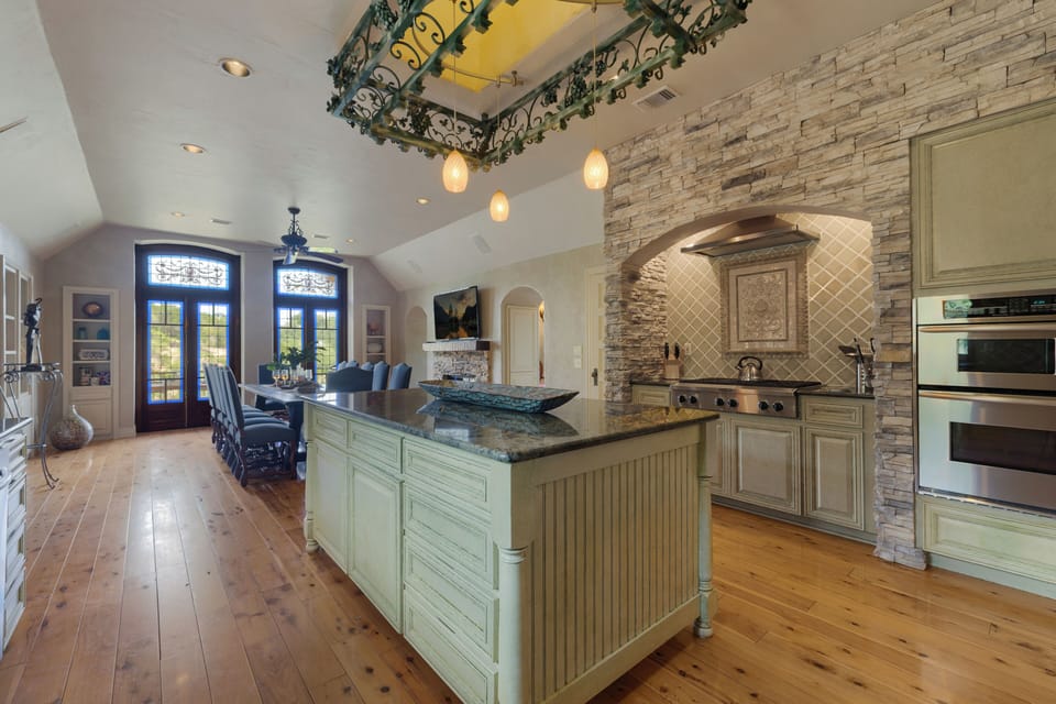 Chef kitchen opening to dining under the vine wrapped balcony
