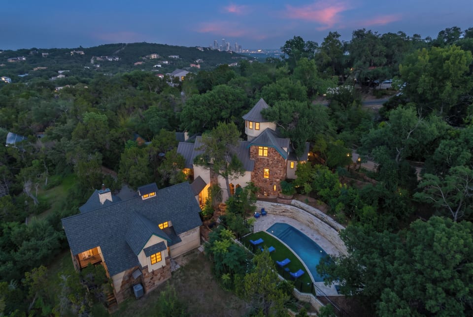 Aerial dusk framing the estate above the Austin skyline