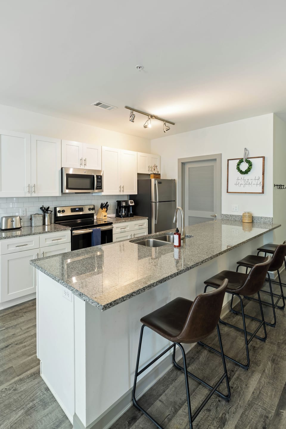 Your fully equipped kitchen awaits, featuring sleek granite countertops, stainless steel appliances, and a spacious island perfect for morning coffee or preparing meals together.