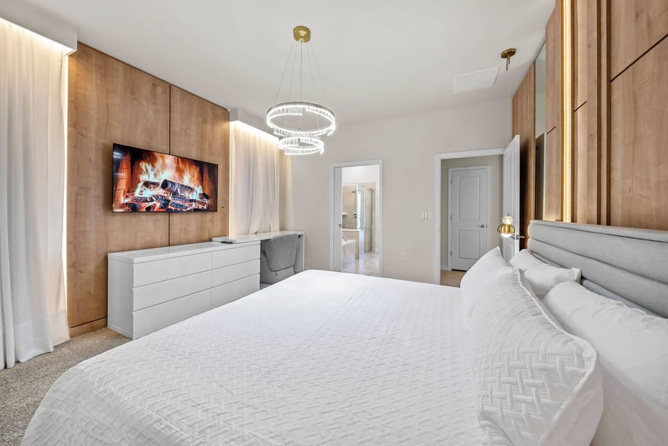 Experience a serene bedroom featuring warm wood paneling and soft neutral tones. The inviting plush bed, complemented by a sleek dresser and modern lighting, creates a perfect atmosphere for relaxation and unwinding.