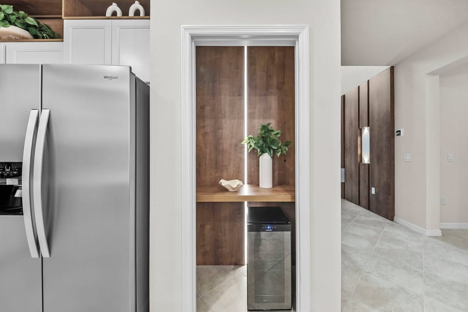 Welcome to this stylish kitchen with sleek stainless steel appliances and a warm wooden accent wall. The smart layout provides ample space for meal prep, all filled with beautiful natural light.