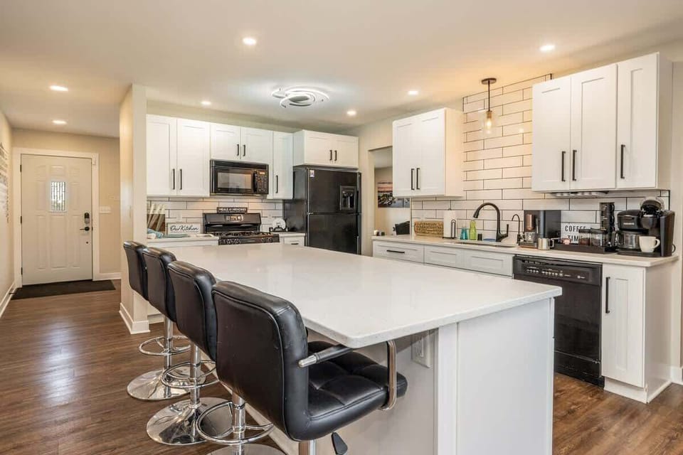 This kitchen is ready for anything—family feasts, pancake flipping contests, or midnight snack raids. With a massive island, full coffee setup, and loads of space to gather, it’s the heart of the home (and maybe the loudest room too).