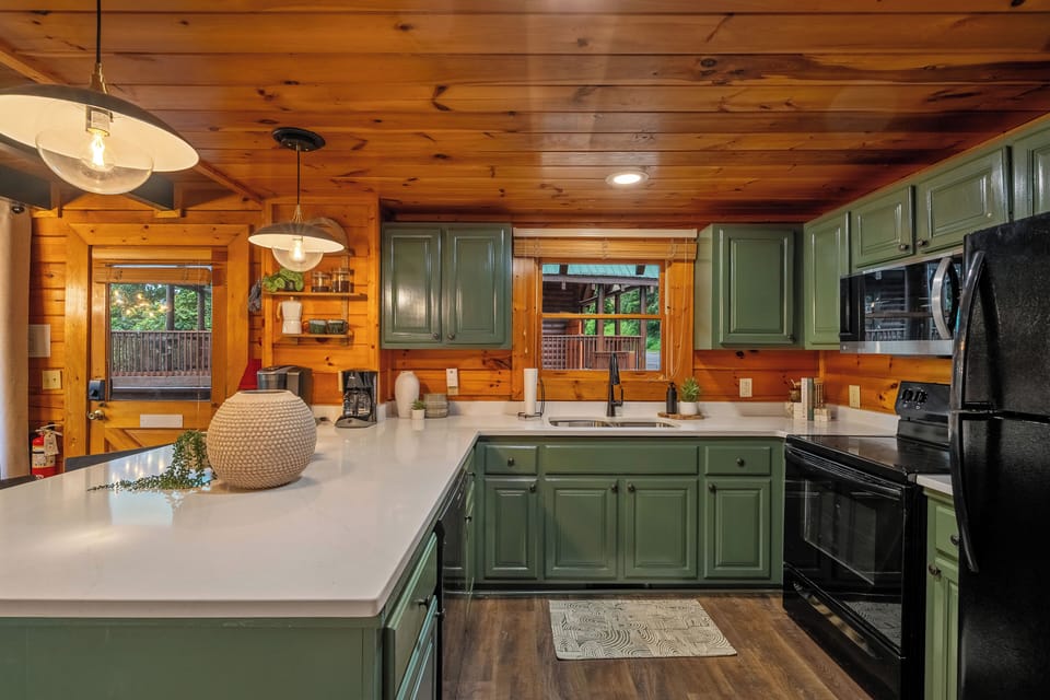 Modern cabin kitchen with spacious island and stylish green cabinets