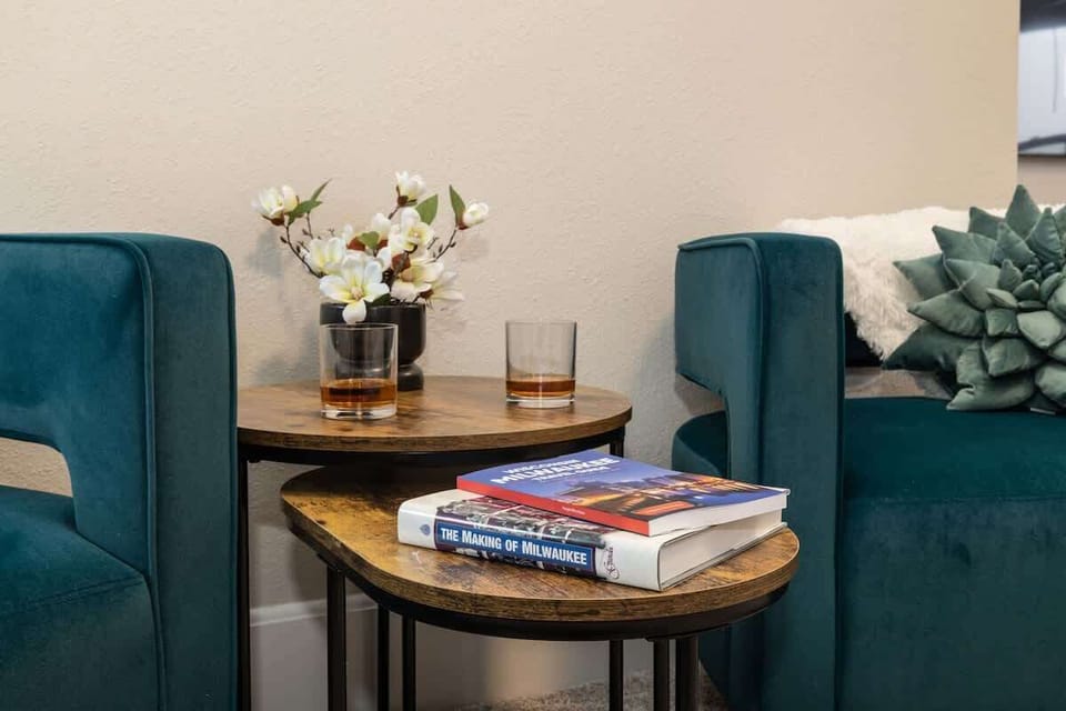 Enjoy a quiet sitting area in the primary suite with comfortable chairs and a small table stocked with books—perfect for reading, unwinding, or enjoying a calm moment to yourself