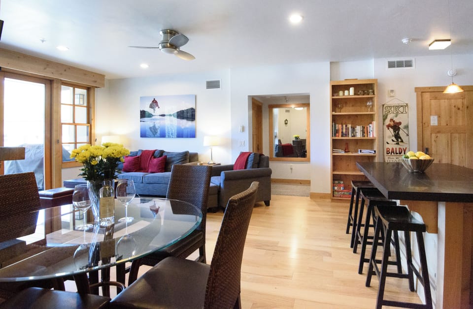 Bright open living area with dining space, breakfast bar, and cozy mountain charm