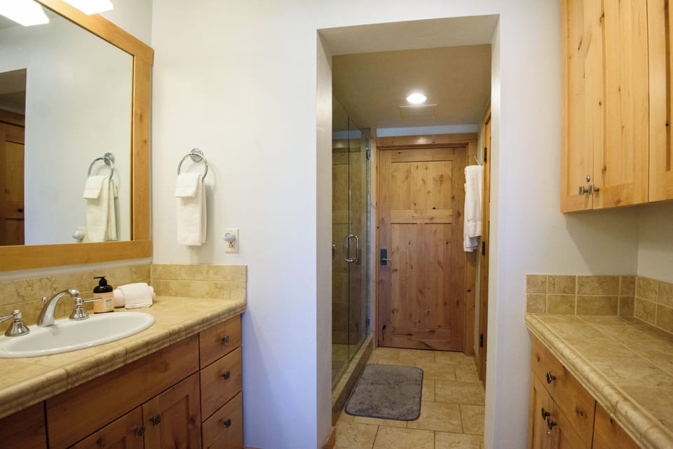 Spacious rustic bathroom with double counter space and walk-in glass shower