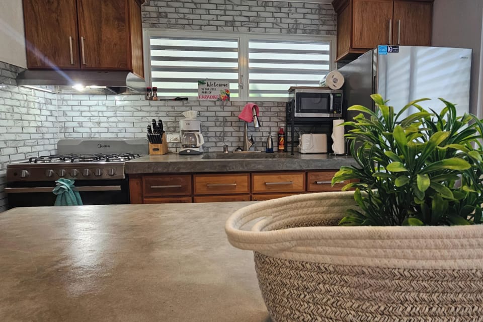 Bright, fully equipped kitchen with gas stove, coffee station, and modern finishes