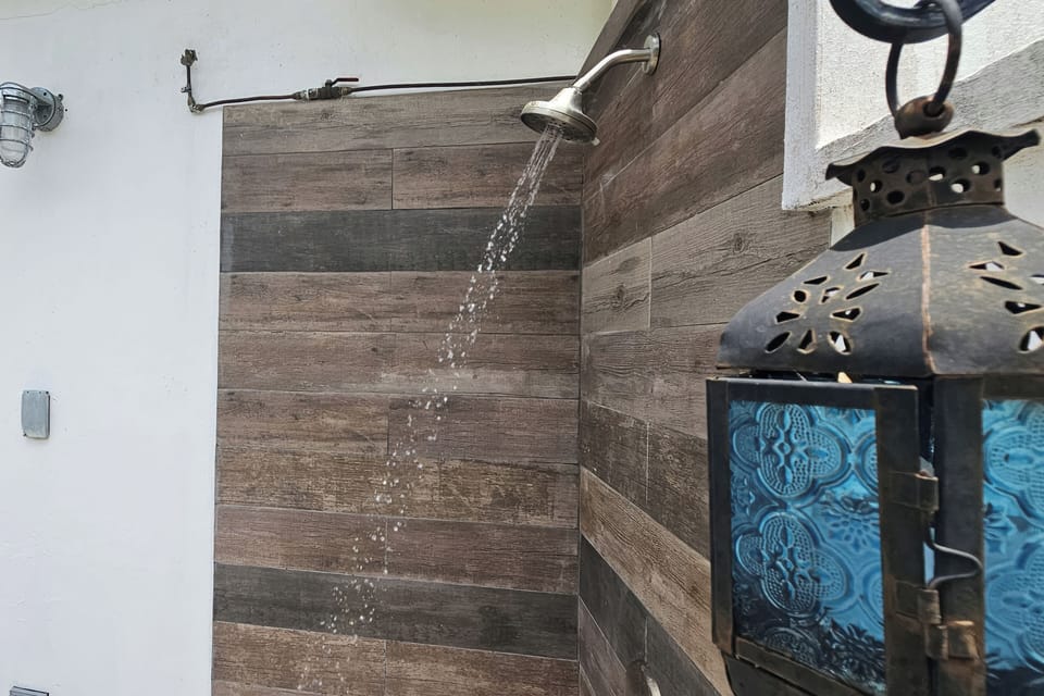 Spa-like outdoor shower with rainfall head and rustic wood-look tile