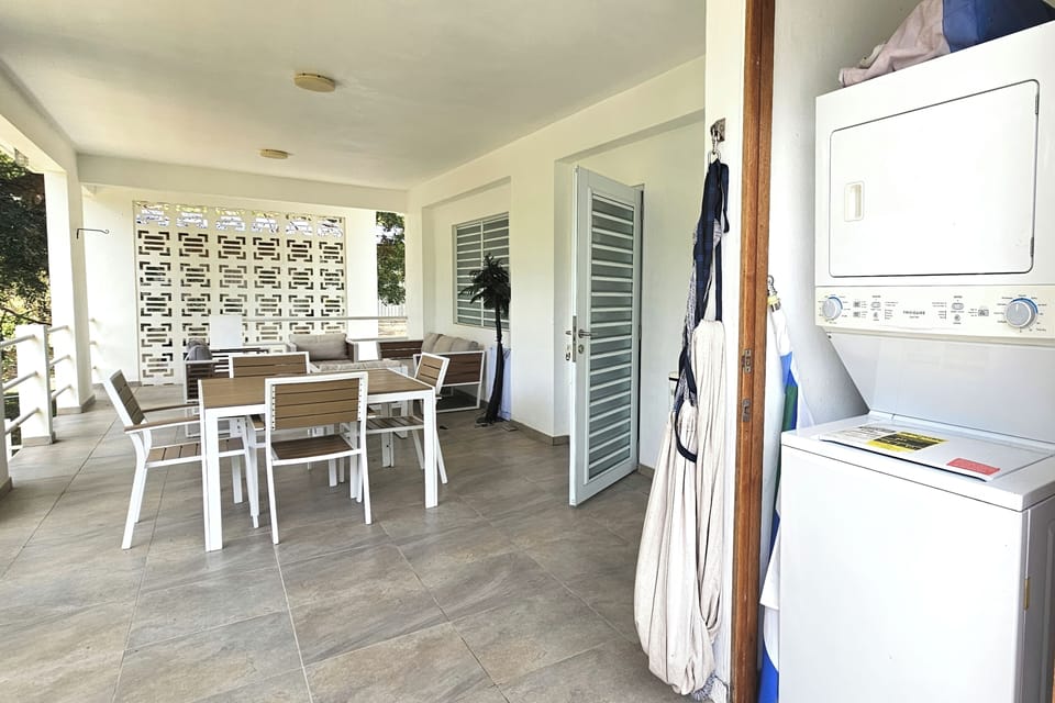 Spacious covered terrace with outdoor dining, lounge seating, and laundry