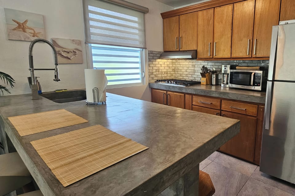 Bright modern kitchen with large island, stainless appliances, and natural light