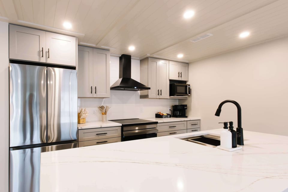 Waterfall quartz countertops in modern, fully stocked kitchen.