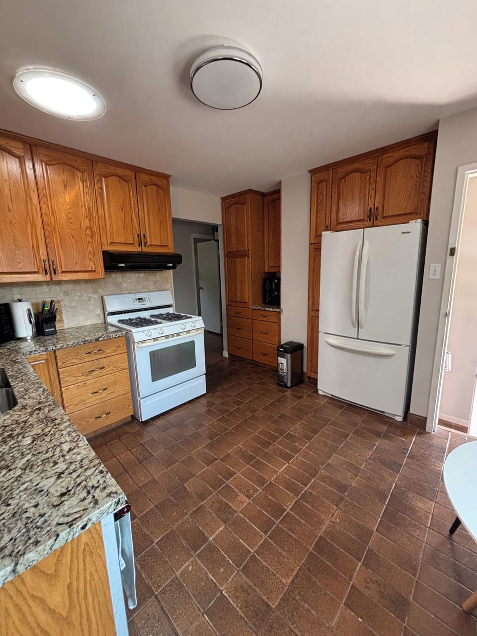 Full kitchen with a gas stove, large fridge with a freezer. Dishes and cutlery.
