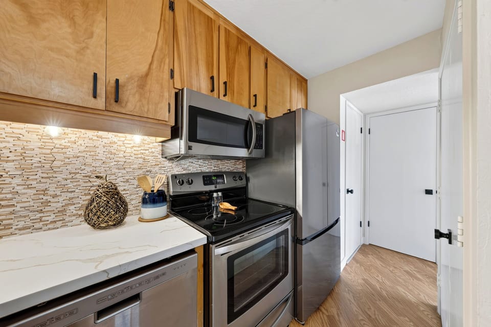 Compact kitchen with wood cabinetry, a coffee station, and counter space for easy snacks or breakfast prep.