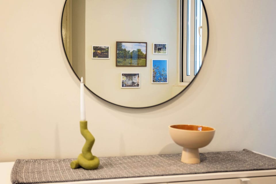 Family photographs beside the rounded mirror