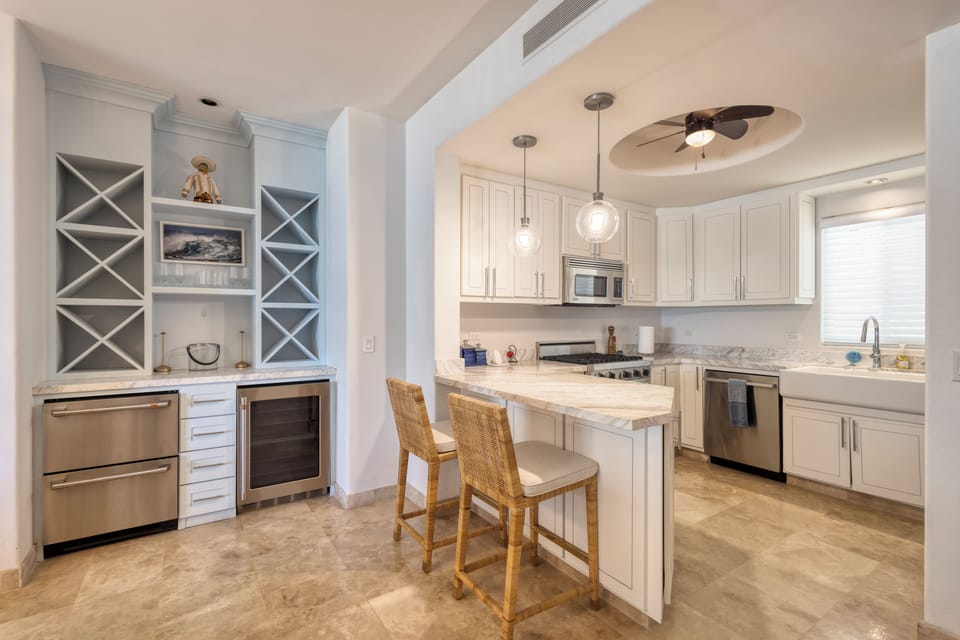 Your fully equipped kitchen awaits with marble countertops, stainless steel appliances, and a cozy breakfast bar—perfect for preparing morning coffee or enjoying a leisurely meal together.