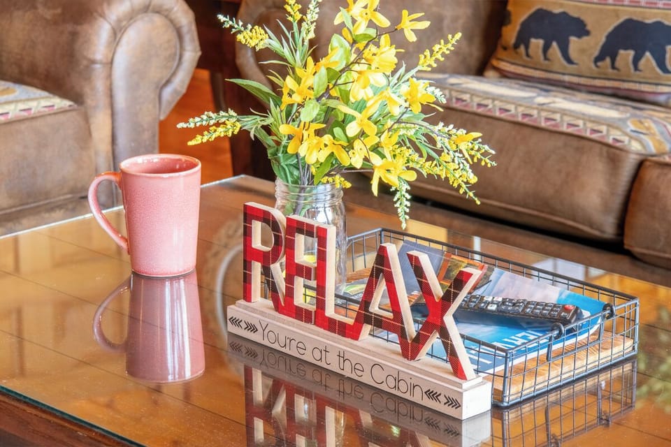 Settle in and relax on your cozy sofa, where rustic charm meets comfort. Cheerful flowers and thoughtful touches make this space feel like home.