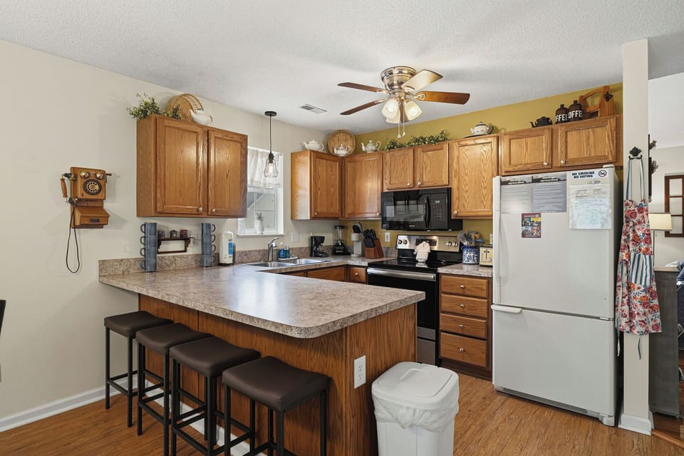 Step into your fully equipped kitchen with warm oak cabinetry, granite counters, and a center island perfect for morning coffee or meal prep. Modern appliances make cooking effortless and enjoyable.