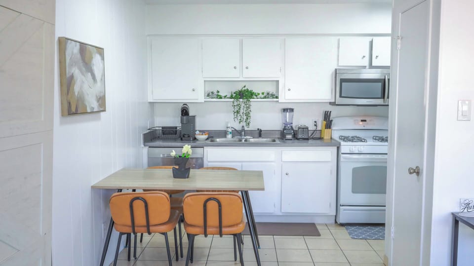 Bright white kitchen with cozy dining nook and full-size appliances