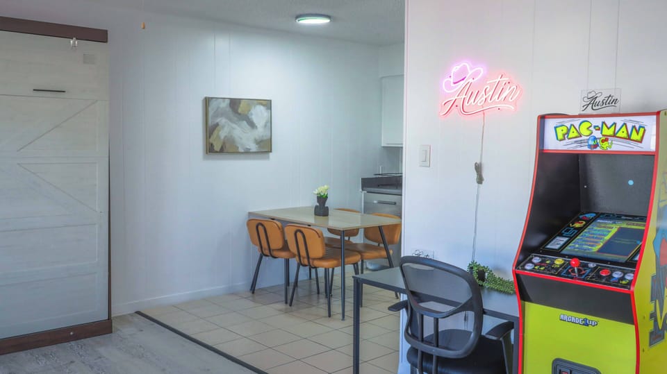 Bright dining nook with retro Pac-Man arcade and Austin neon flair