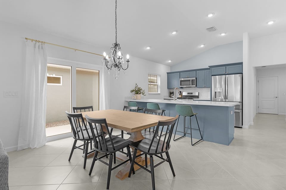 Gather around the elegant dining table or perch at the island in this bright, open-concept space featuring a fully equipped kitchen with modern appliances, custom cabinetry, and recessed lighting throughout.