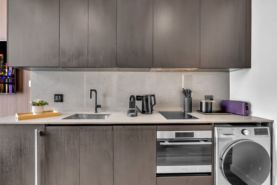 Kitchen essentials at a glance: cooktop, oven, coffee maker, kettle, toaster, and knife set, plus an in-unit washer/dryer and generous cabinet storage.