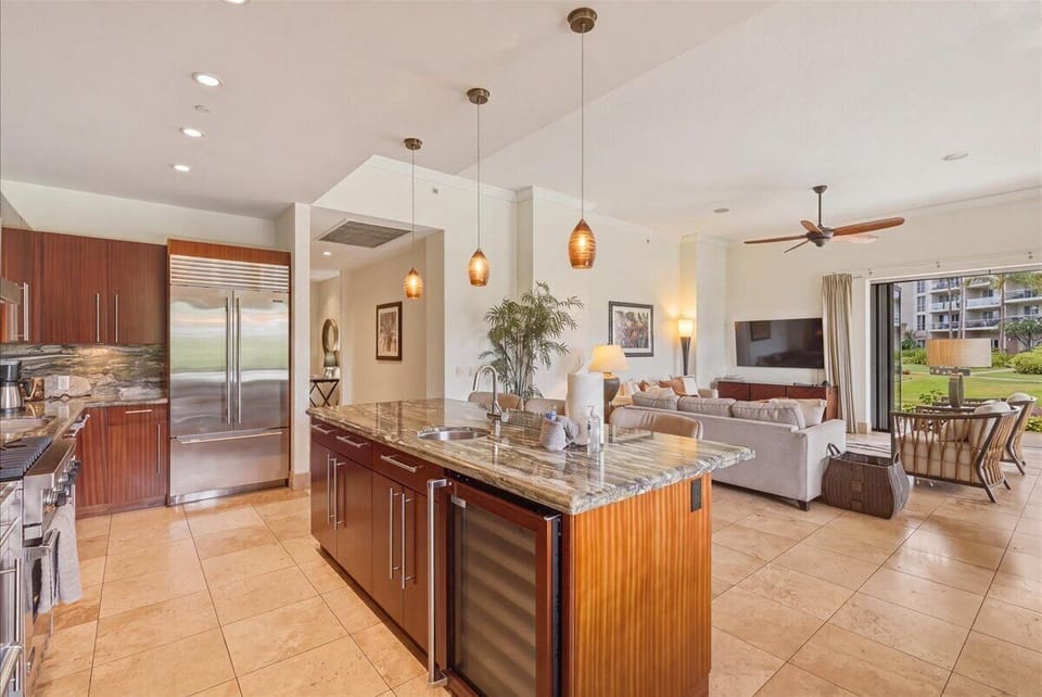 Your spacious gourmet kitchen flows seamlessly into the living area, featuring granite countertops, stainless steel appliances, and warm pendant lighting for memorable meals.