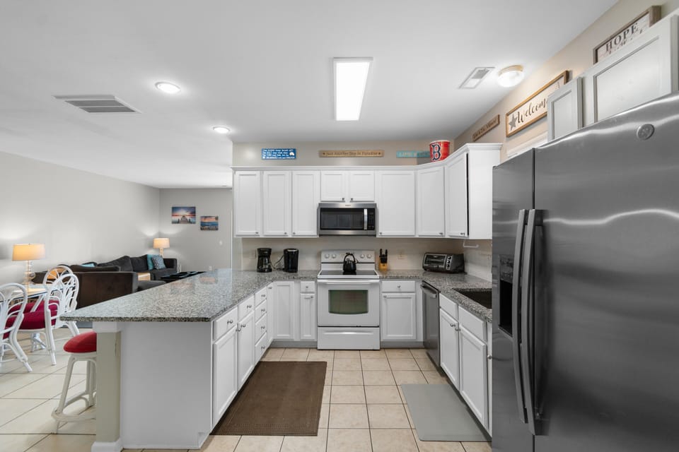 You'll love preparing meals in this bright, fully equipped kitchen with modern appliances, granite counters, and easy flow to your cozy living space.