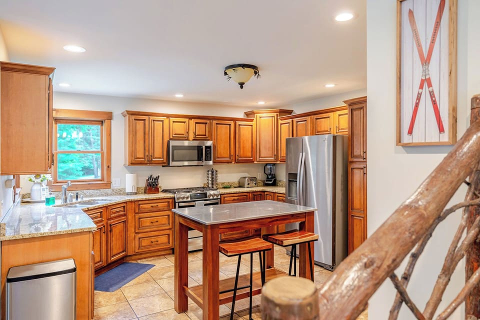 Fully equipped gourmet kitchen with granite countertops, stainless steel appliances, and ample workspace.