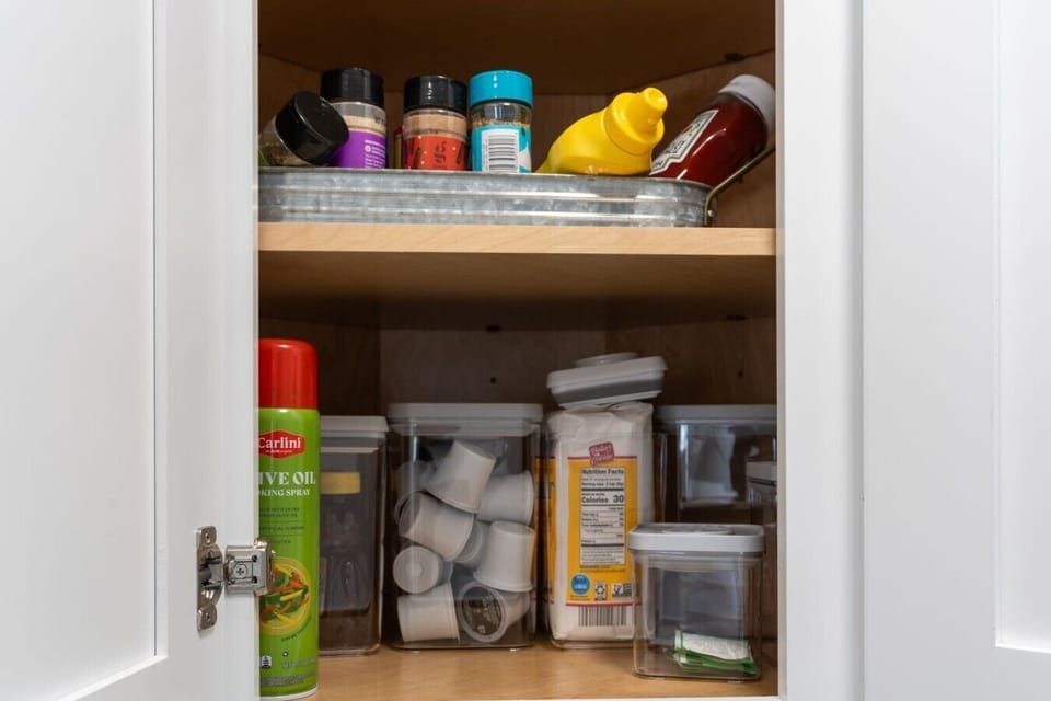 The pantry is stocked with cooking basics including spices, coffee supplies, condiments, and kitchen staples to make preparing meals even easier.