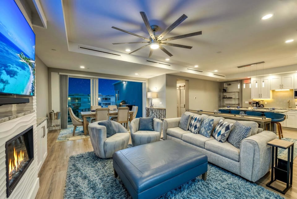 The sleek fireplace and mounted TV create the perfect setting for movie nights after a day at the beach.