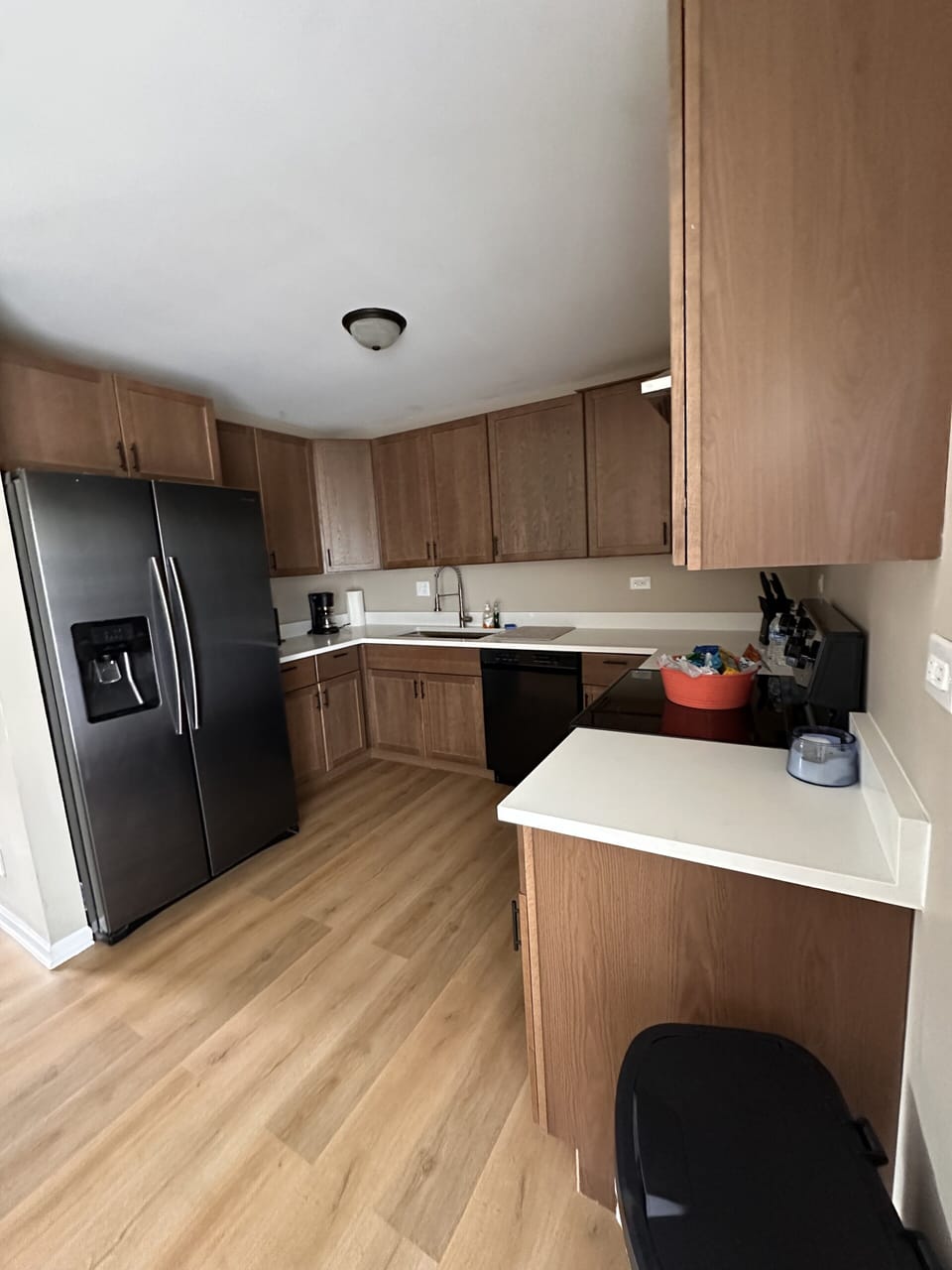 Spacious kitchen with warm wood cabinets and sleek black appliances