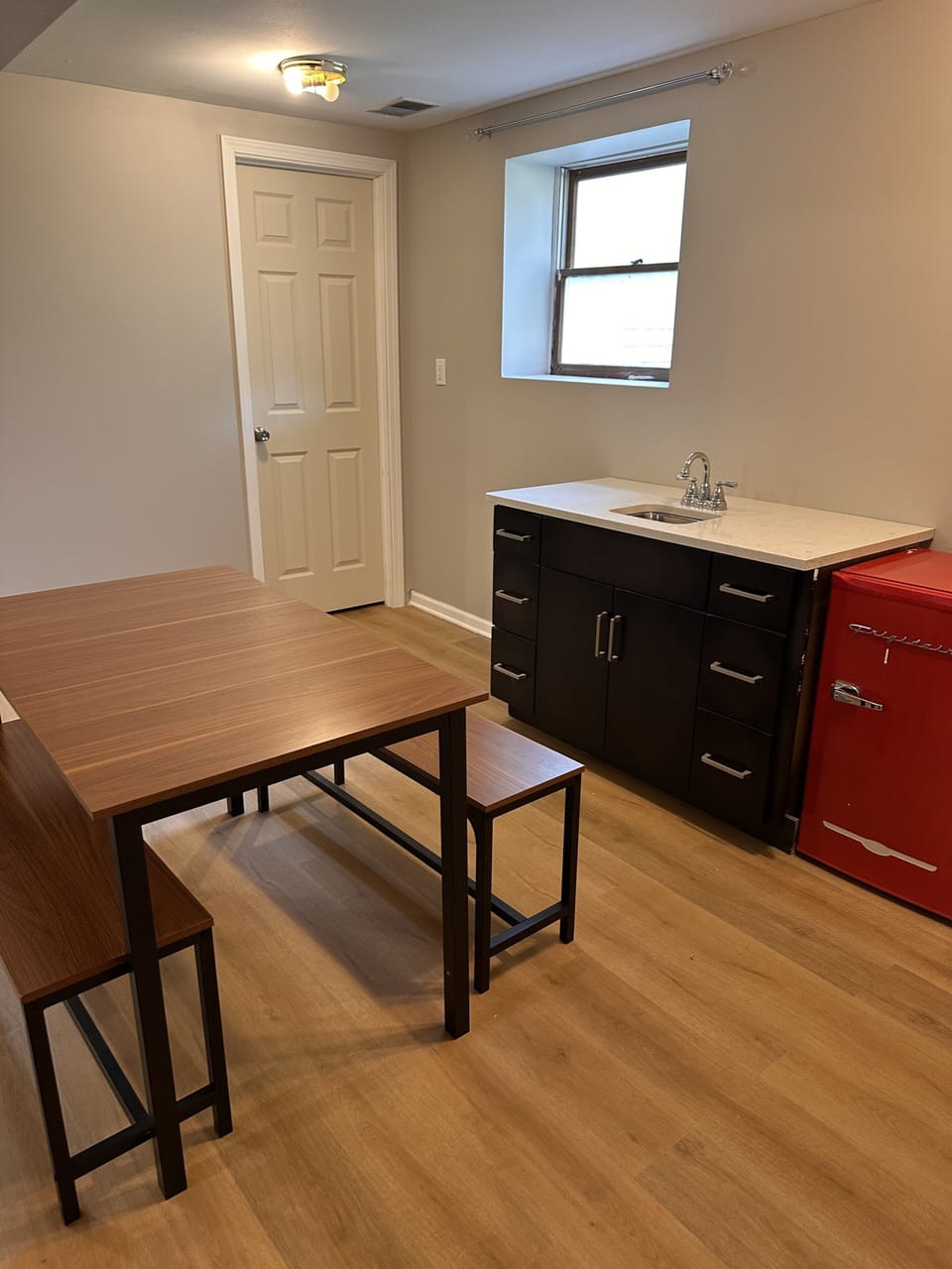 Cozy kitchenette with dining nook and stylish retro red mini fridge