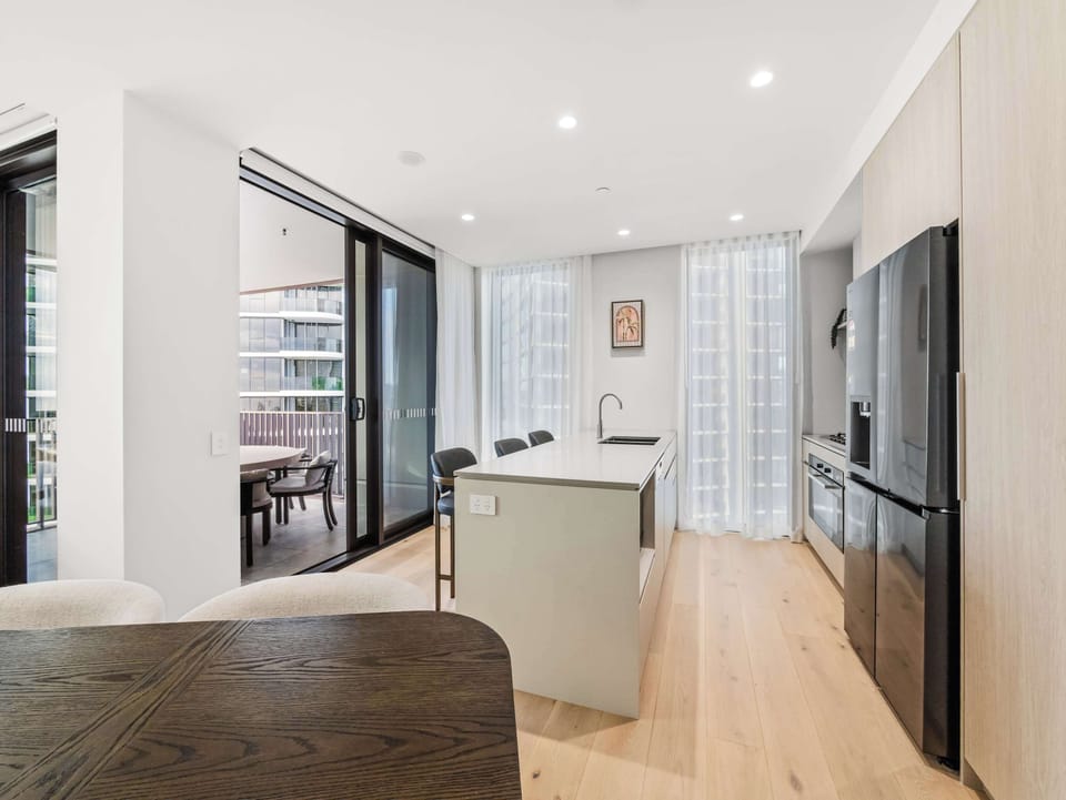 Kitchen island with seating, opening through to the balcony.