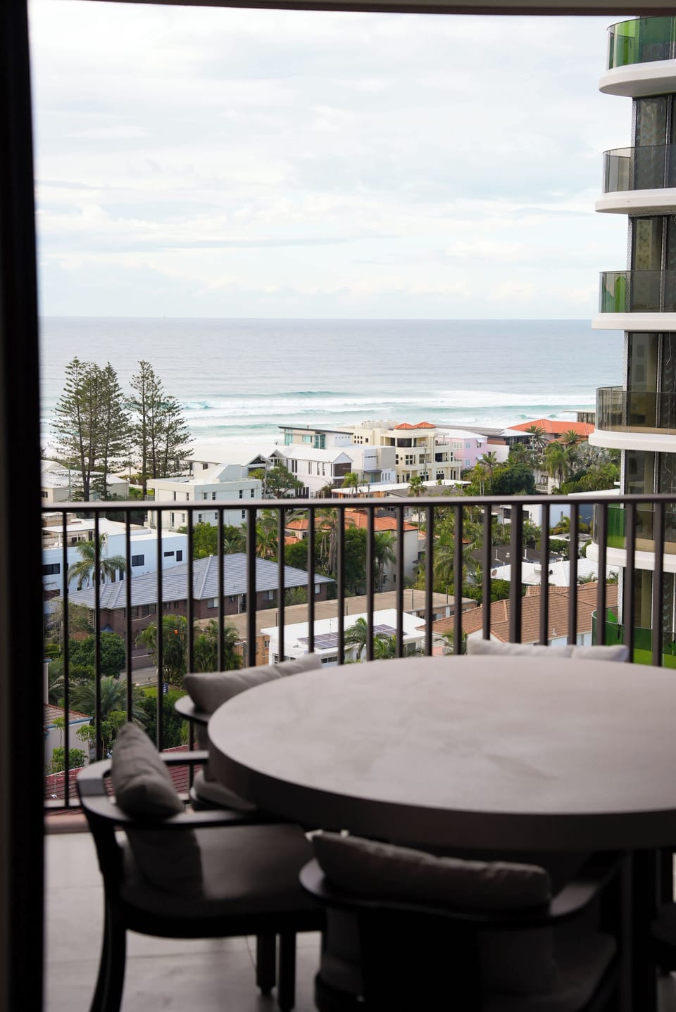 The balcony table, set above the rooftops with the surf beyond.