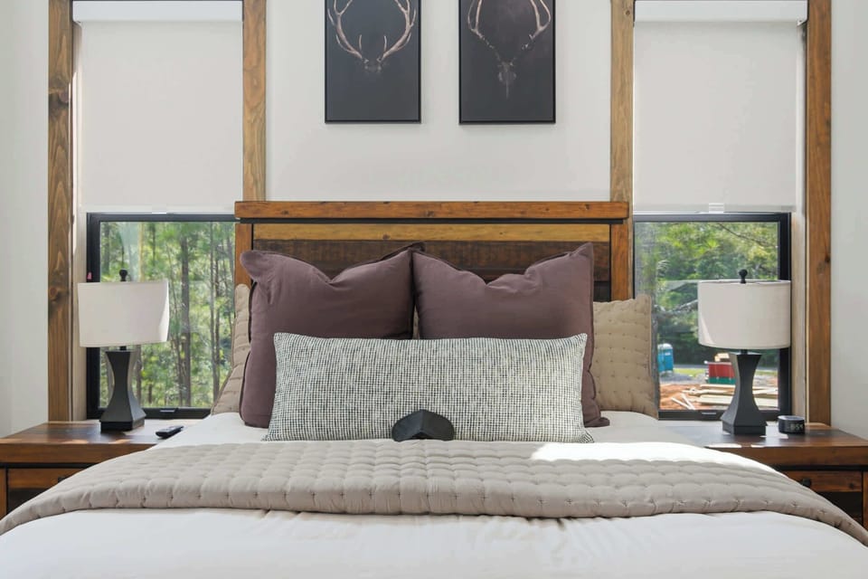 A private retreat awaits in Bedroom 2, featuring a queen bed, ensuite, and balcony overlooking Walnut Peak
