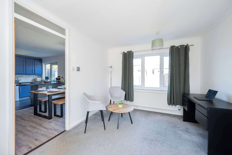 Open-plan living and dining space with glimpse of the designer blue kitchen — bright, spacious and welcoming