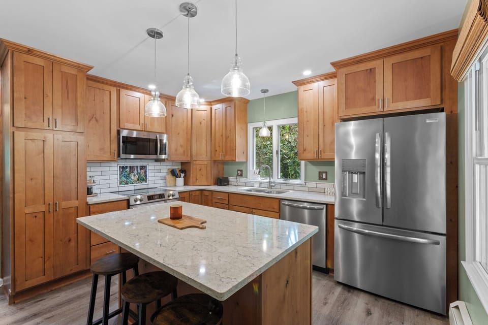 Bright chef’s kitchen with quartz island and stainless steel appliances