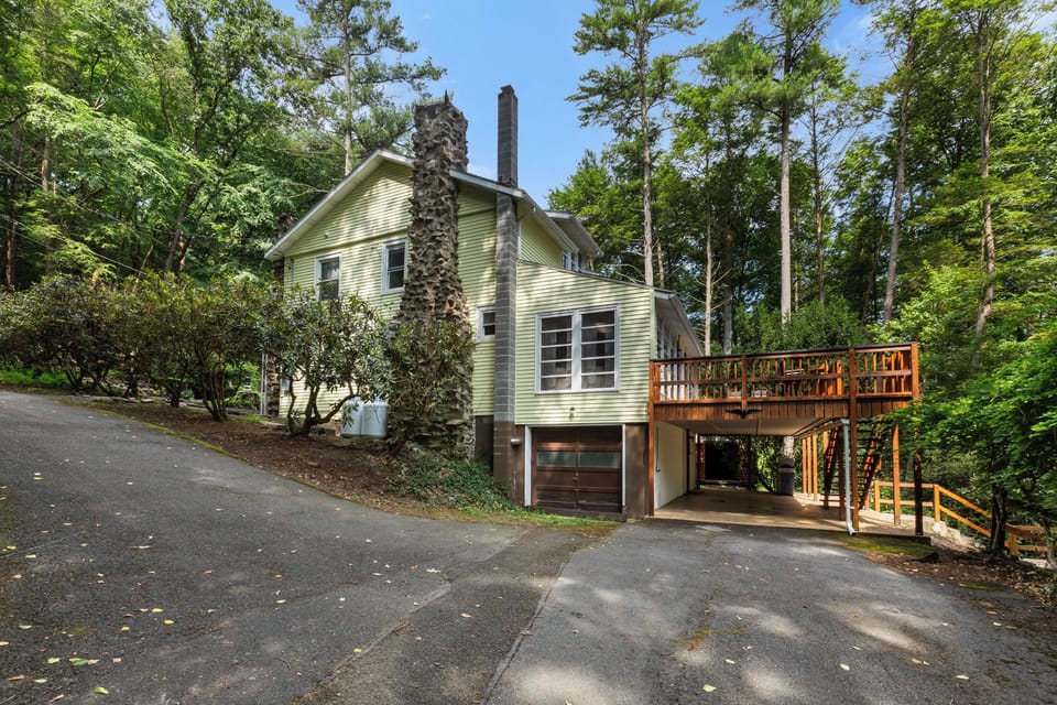 Secluded woodland retreat with spacious deck, driveway, and rustic charm