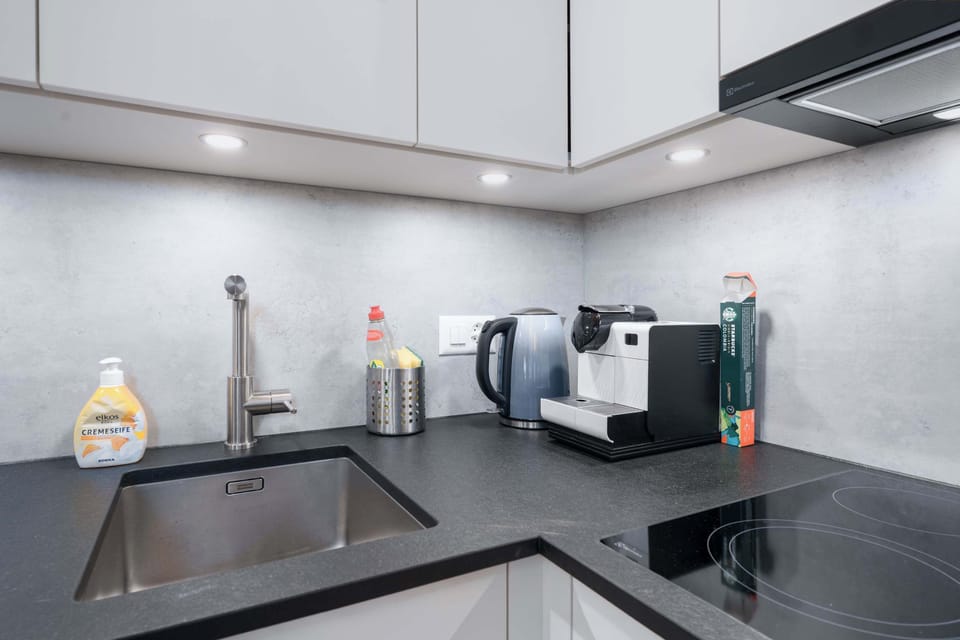 Well-equipped kitchen with coffee machine, cooking essentials, and practical workspace.
