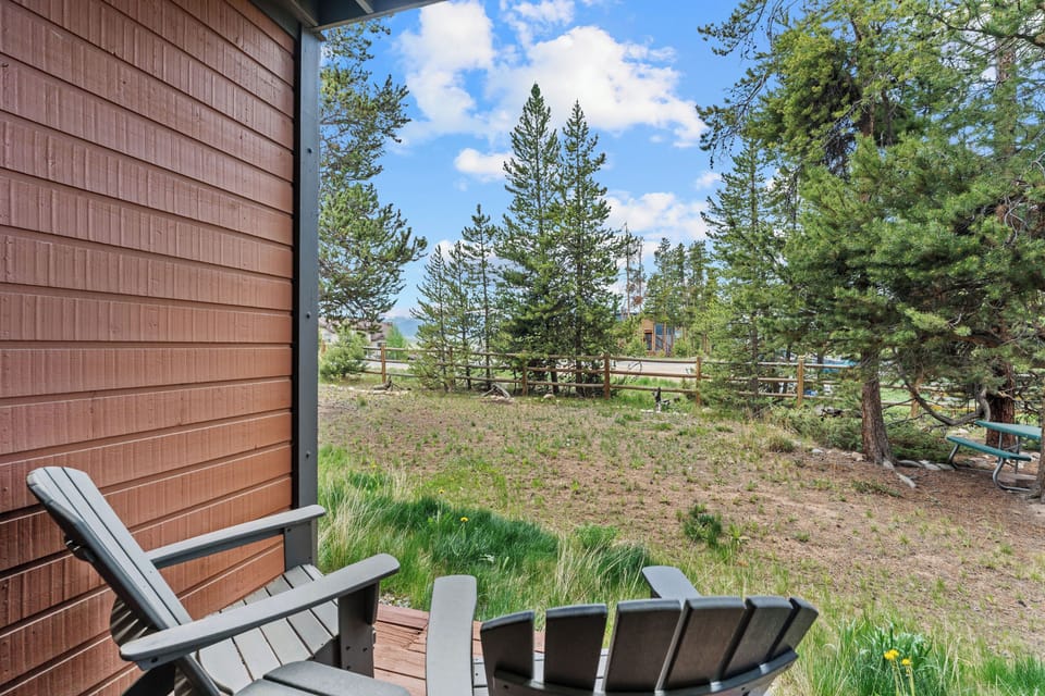 A private mountain retreat nestled among towering pines, offering serene views and peaceful outdoor space near a neighboring property.