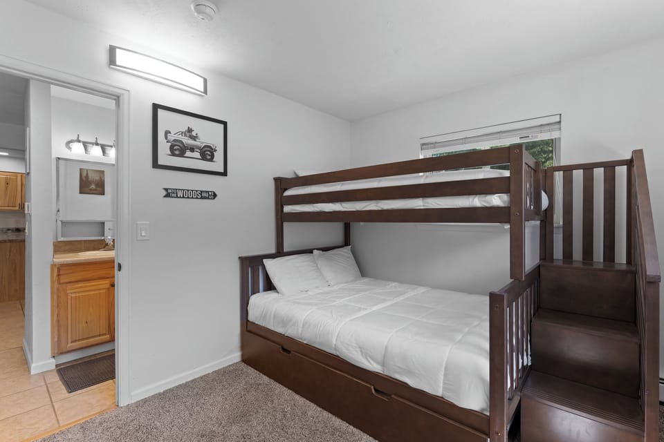 Your kids will love this cozy bedroom with sturdy bunk beds featuring built-in stairs and a fresh, bright atmosphere perfect for bedtime stories and morning adventures.
