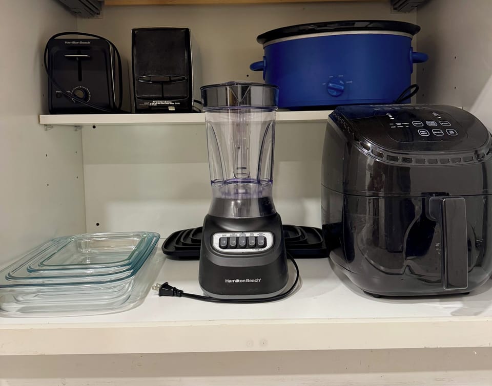 Well-equipped kitchen with air fryer, blender, slow cooker, and more
