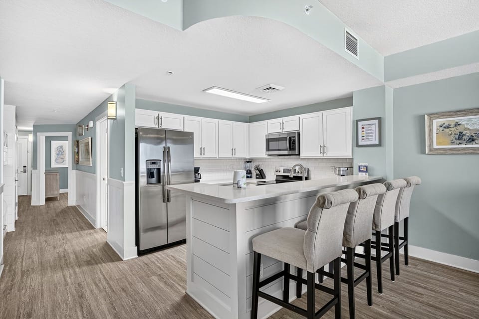 Your fully-equipped kitchen invites you to gather with loved ones around the spacious island, where cooking and conversation blend effortlessly in this bright, open space.