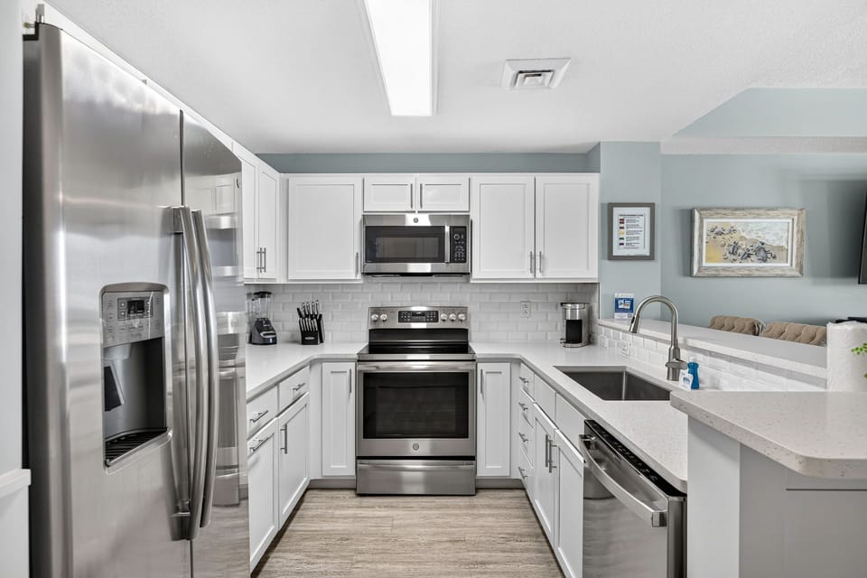 Prepare your favorite meals in this bright, fully equipped kitchen featuring stainless steel appliances, crisp white cabinetry, and ample counter space for easy cooking and gathering.
