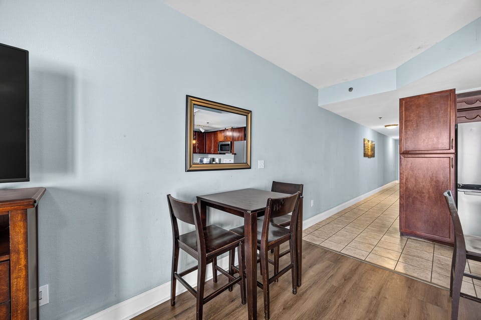Your cozy dining space features a high-top table with plush seating, perfect for morning coffee or casual meals while enjoying the open layout and calming coastal hues.