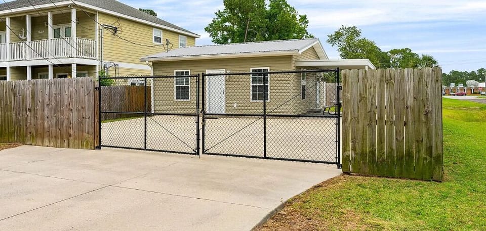 A single-level property in a quiet residential neighborhood, featuring a fenced driveway with gated entry and a covered carport for your vehicle.