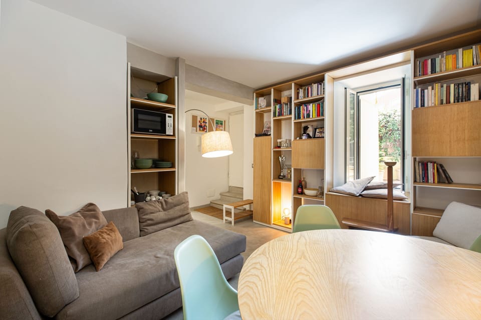 The sofa faces the bookcase wall; three steps up to the front door