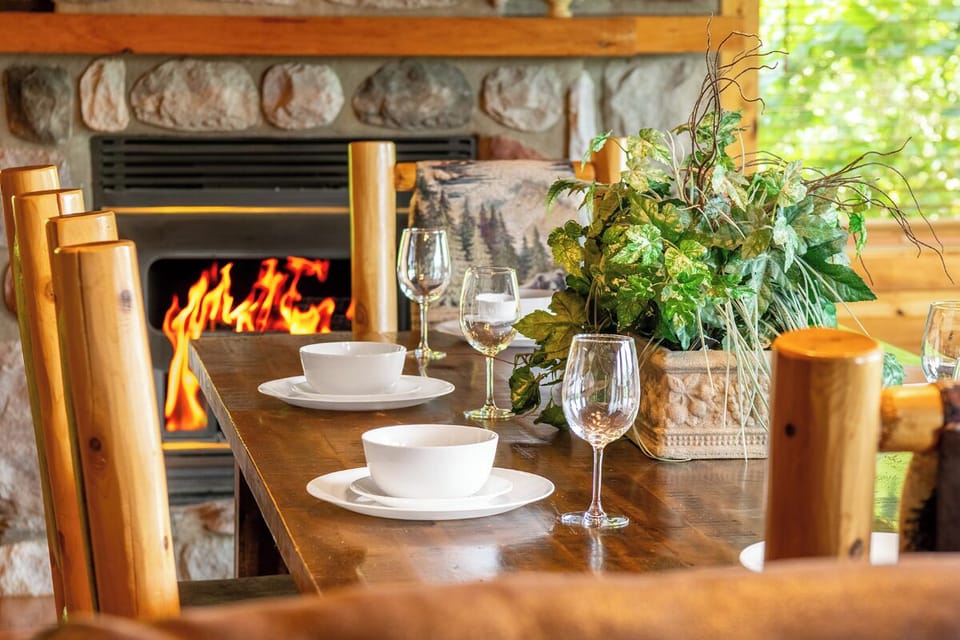 Gather around the warm fireplace for cozy meals at this inviting dining table, where rustic charm meets comfort. Natural light streams in, creating your perfect mountain retreat.