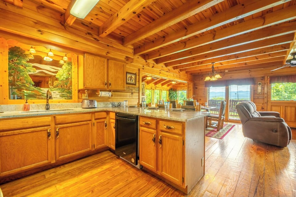 Step into this inviting open-concept space where rustic charm meets modern convenience. Warm wood beams overhead and a fully equipped kitchen invite you to cook while staying connected to your group, with seating and relaxation areas just steps away.