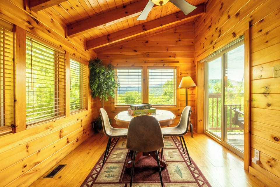 Gather around the sunlit table and enjoy meals with mountain views framed by warm pine walls. The ceiling fan and natural light create a welcoming space where your group can linger over coffee and plan the day's adventures.